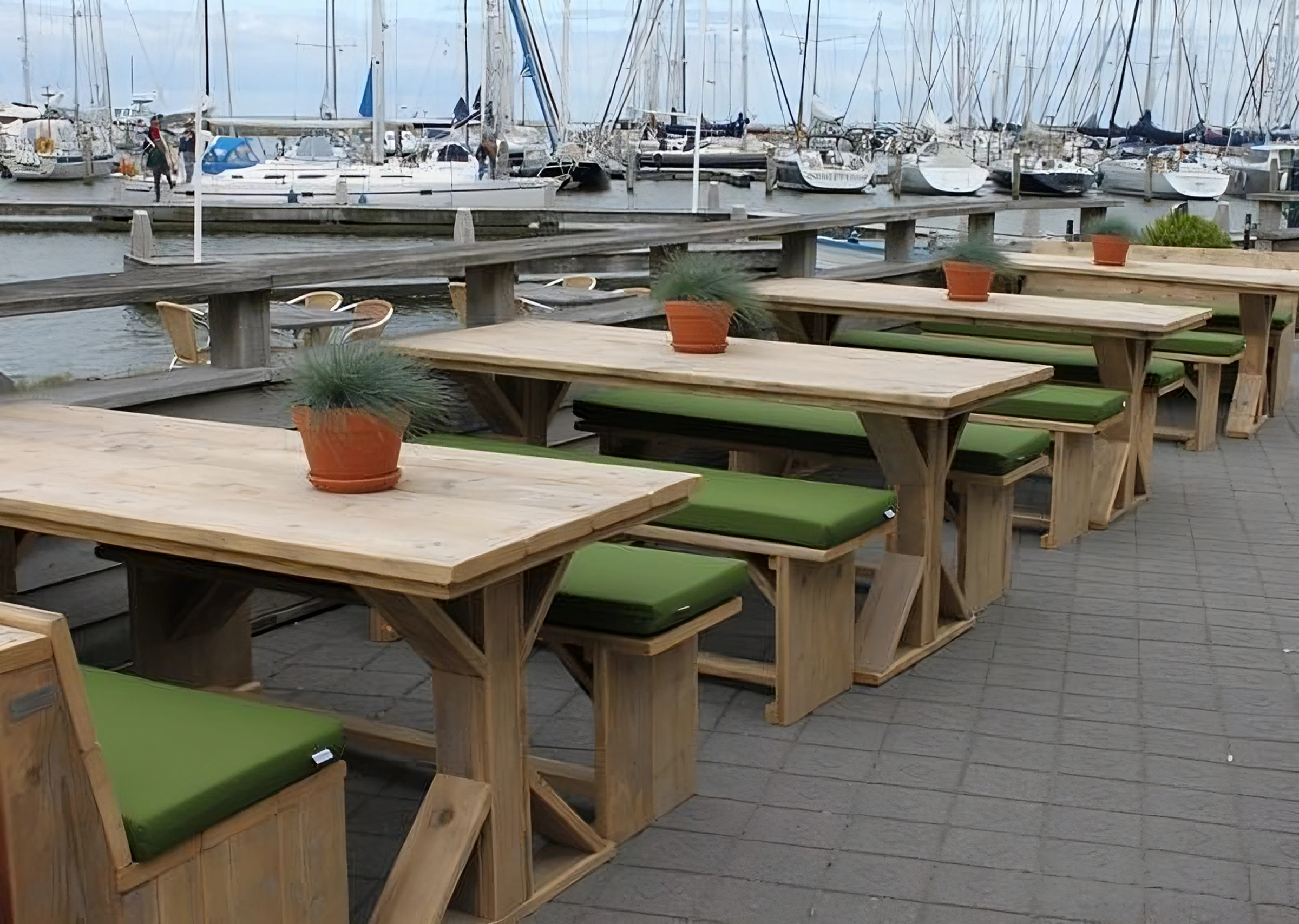 Olijf groene Cartenza Uni kussens bij een restaurant aan de haven